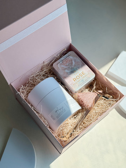 Gift set with a rose shaped candle, meditation cards and wick trimmer in a pink box.