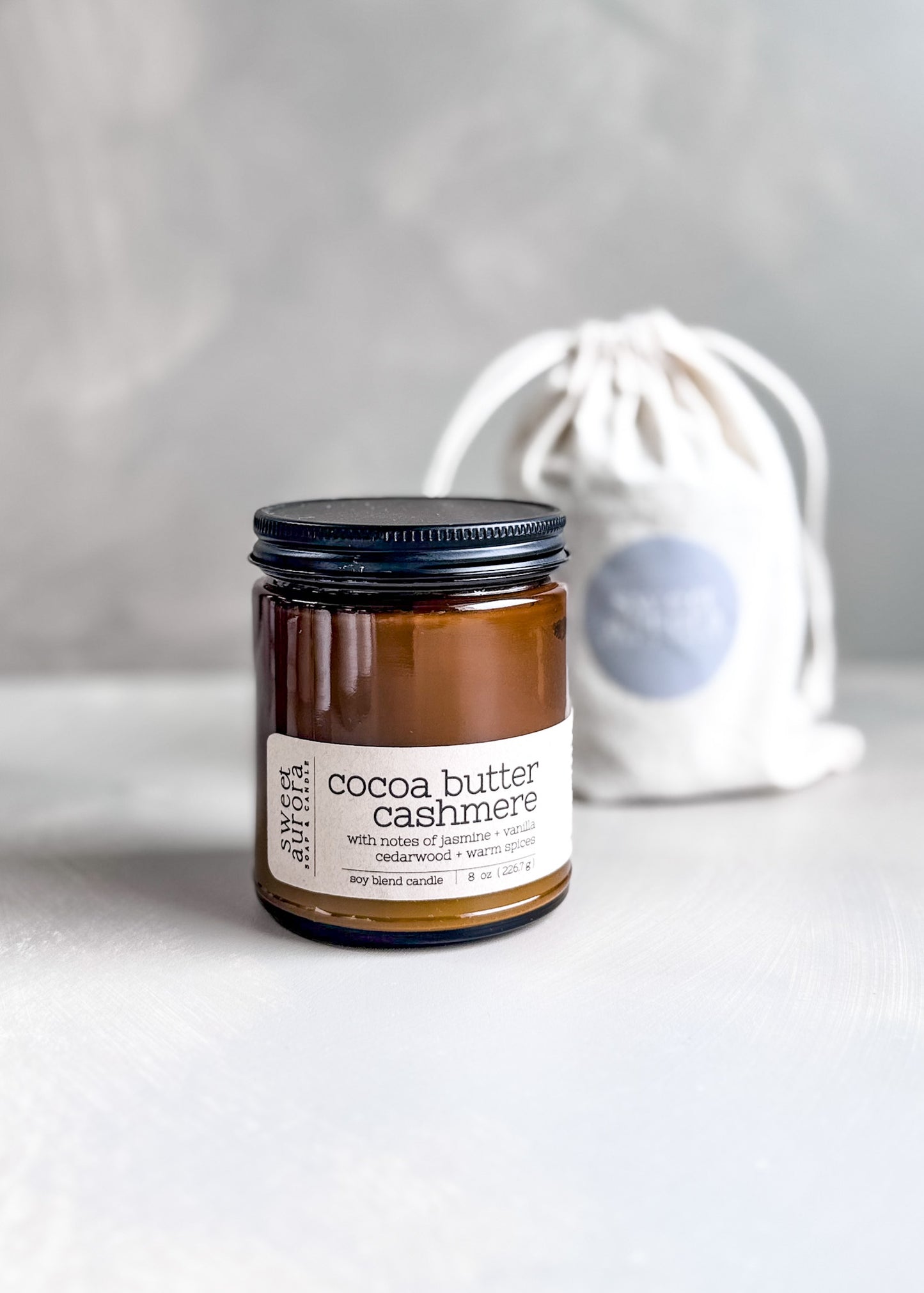 Cocoa Butter Cashmere soy cotton wick candle in amber jar with branded gift bag
