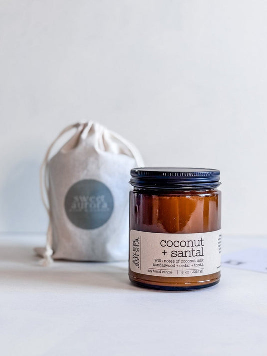 Coconut + Santal soy cotton wick candle in amber jar with branded gift bag