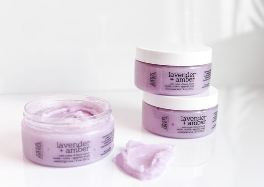 Lavender + Amber sugar scrub jars with open jar showing exfoliating texture