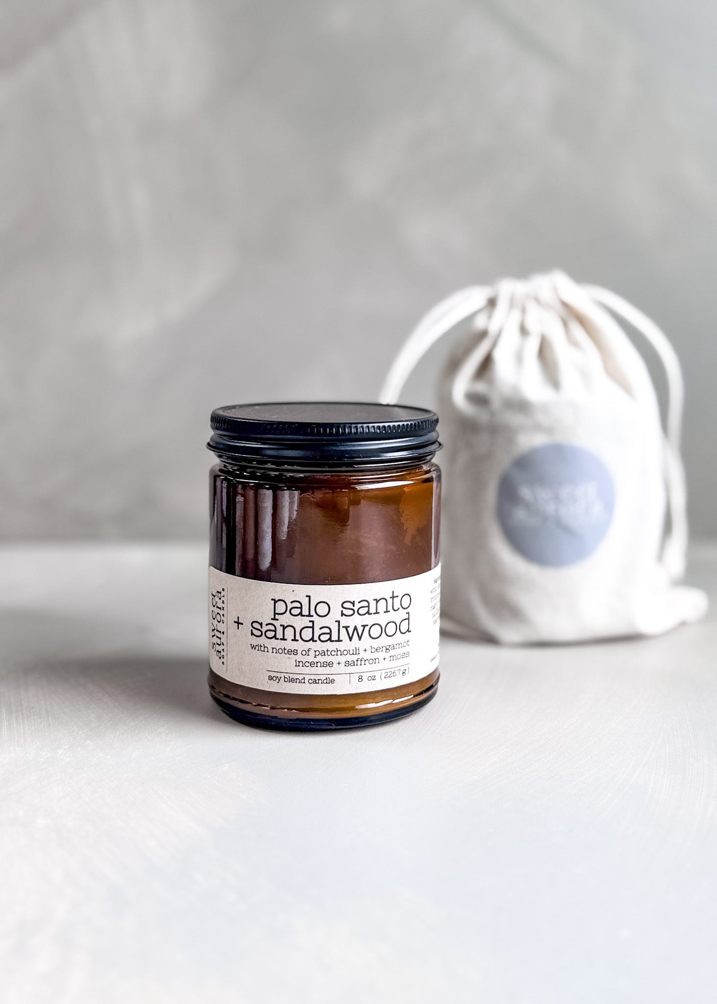 Palo Santo + Sandalwood soy cotton wick candle in amber jar with branded gift bag