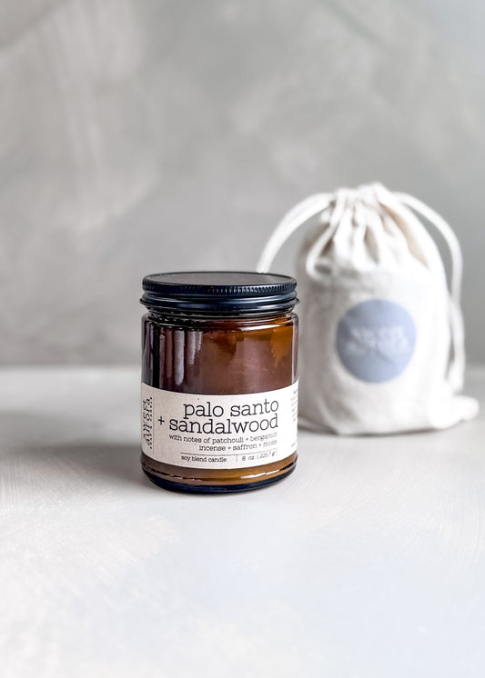 Palo Santo + Sandalwood soy cotton wick candle in amber jar with branded gift bag