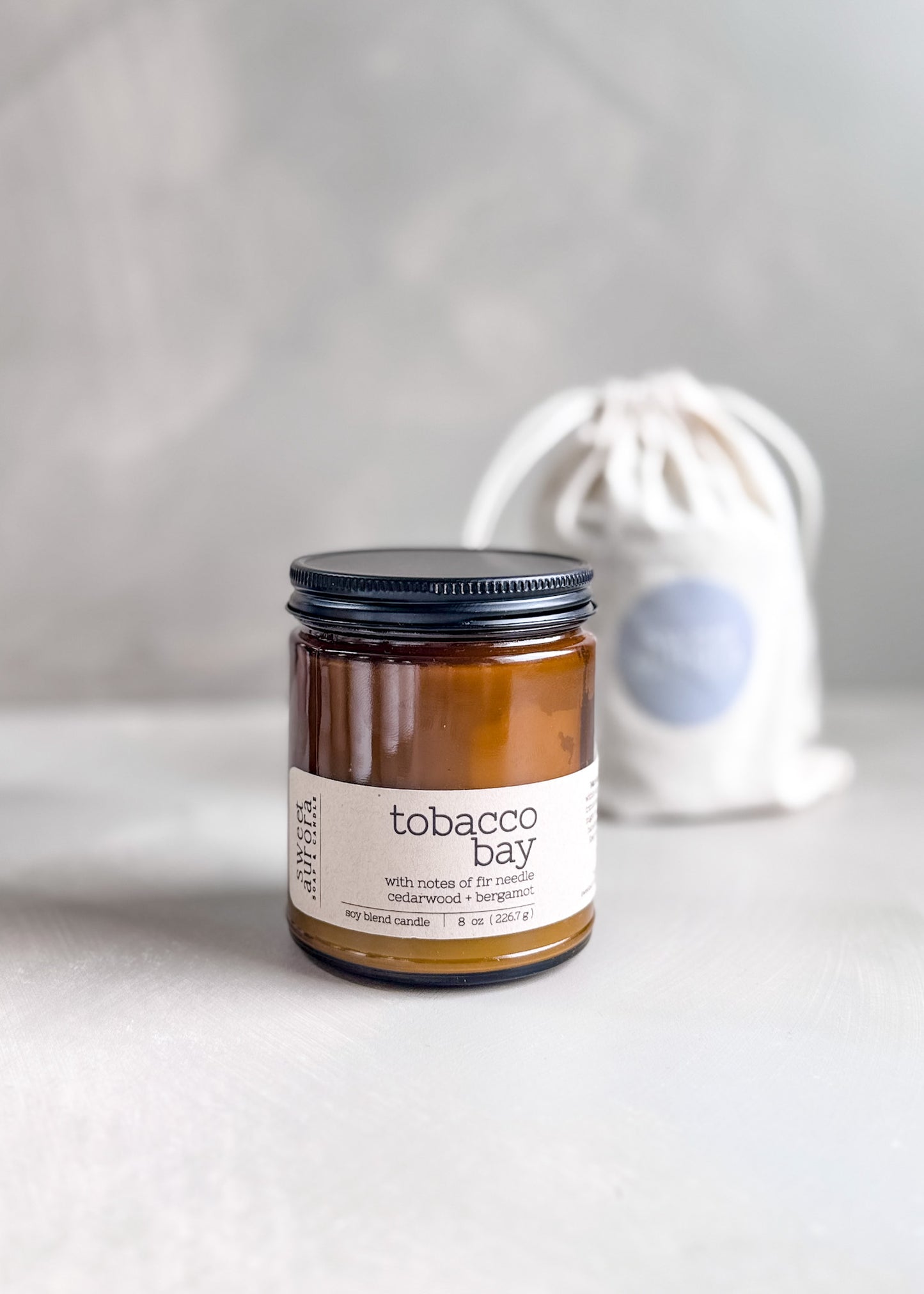 Tobacco Bay soy cotton wick candle in amber jar with branded gift bag